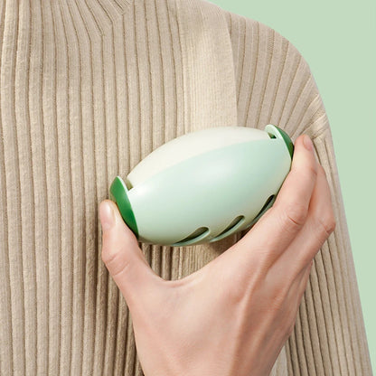 A person is holding a reusable lint roller in their hand, demonstrating how it is used to roll up a piece of fabric.